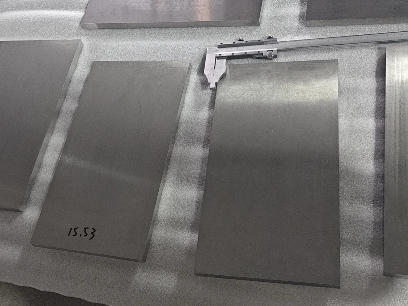 Titanium plate samples and a caliper for dimensional review