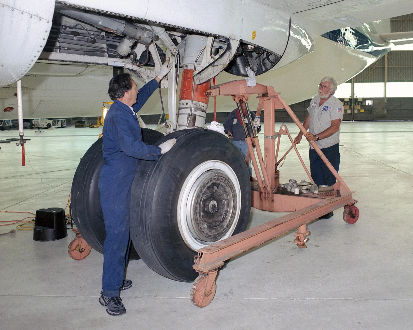 NASA technicians working on an aircraft main landing-gear assembly
