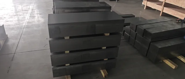 Rectangular titanium billet stock stacked on timber supports