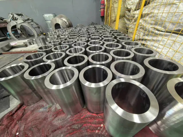 Machined titanium forgings arranged on a workshop floor