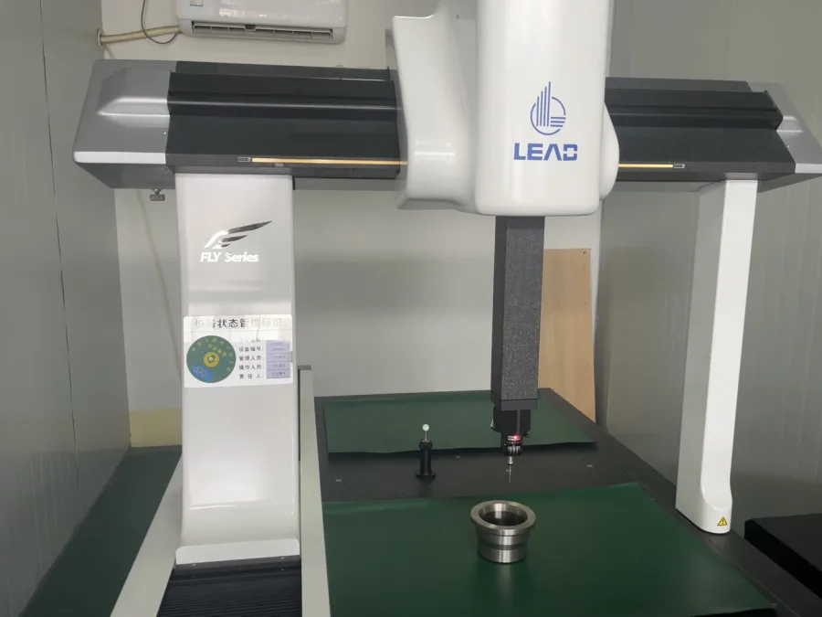 A coordinate measuring machine inspecting a metal component on its measurement table