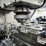 5-axis CNC milling process on titanium precision part with coolant in action