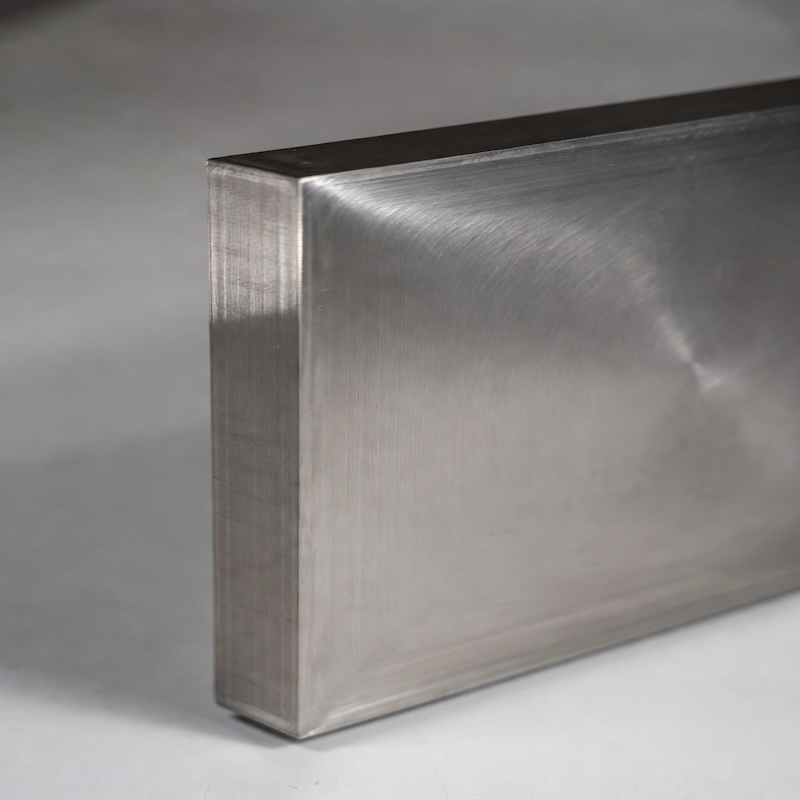 Side view of titanium build plate showing precise thickness and clean machined edges for metal additive manufacturing