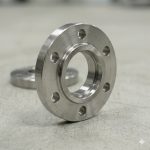 Close-up side angle of a titanium weld neck flange with detailed raised face and machined edges, high precision titanium flange