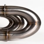 Detailed close-up of titanium heat exchanger coil tubing showing seamless weld and high-purity metallic texture