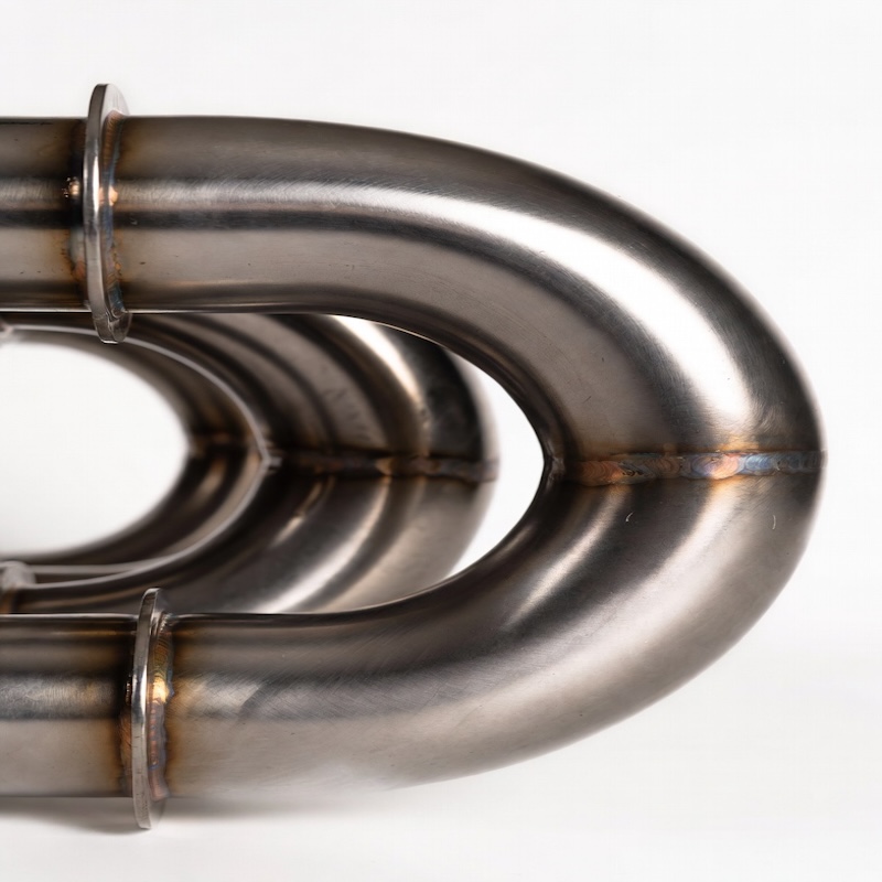 Detailed close-up of titanium heat exchanger coil tubing showing seamless weld and high-purity metallic texture