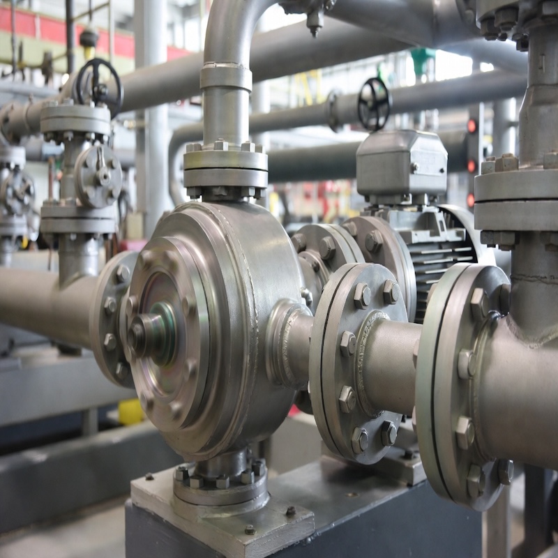 Compact magnetic drive titanium pump (ITM series) mounted on stainless steel base in industrial setting, highlighting zero-leakage sealed design