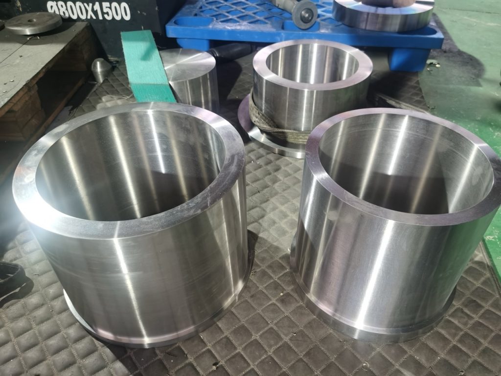 Machined forged titanium rings and sleeves on a workbench