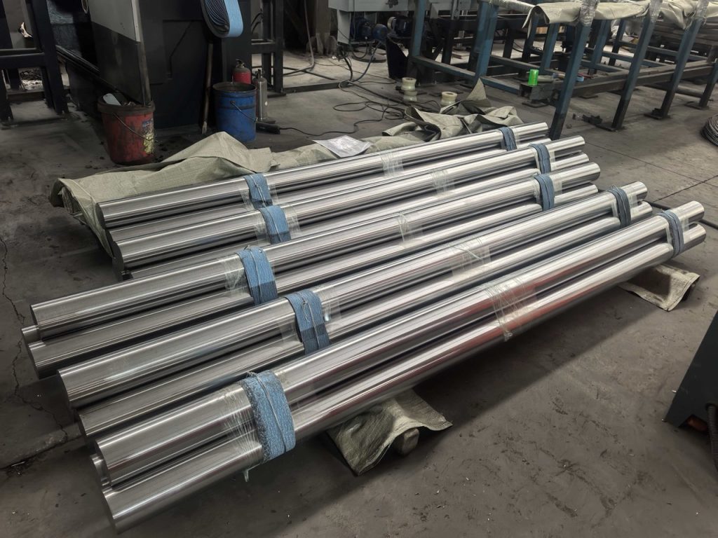 Bundled machined Ti-6Al-4V titanium round bars on a workshop floor