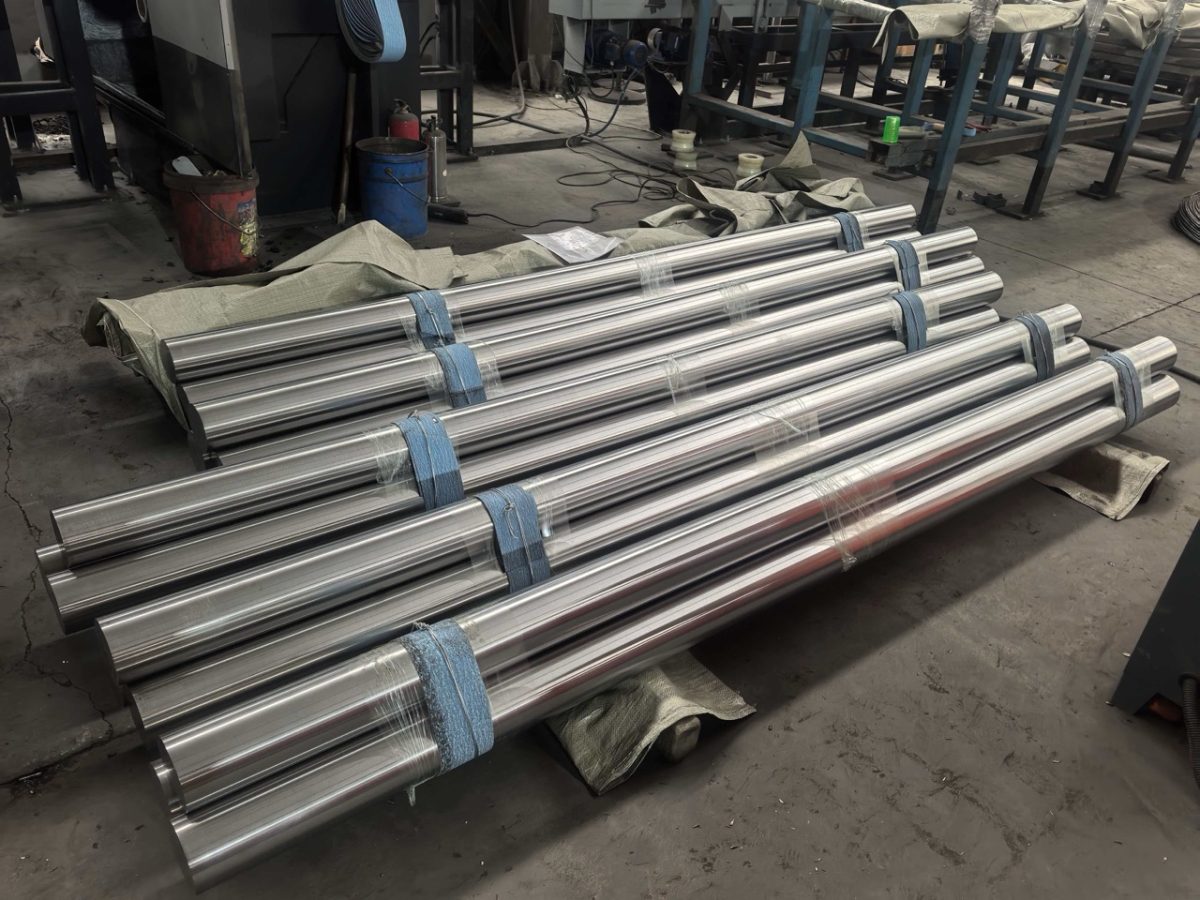Bundled machined Ti-6Al-4V titanium round bars on a workshop floor