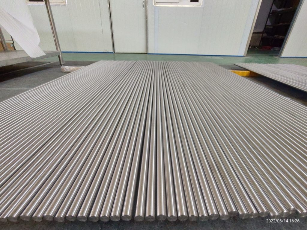 Array of titanium round bar stock laid out in a workshop
