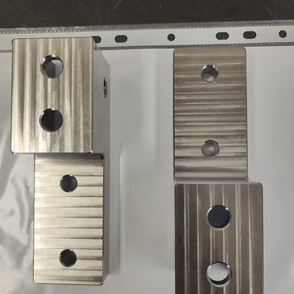 Finished titanium brackets from an anonymized German automotive machining project