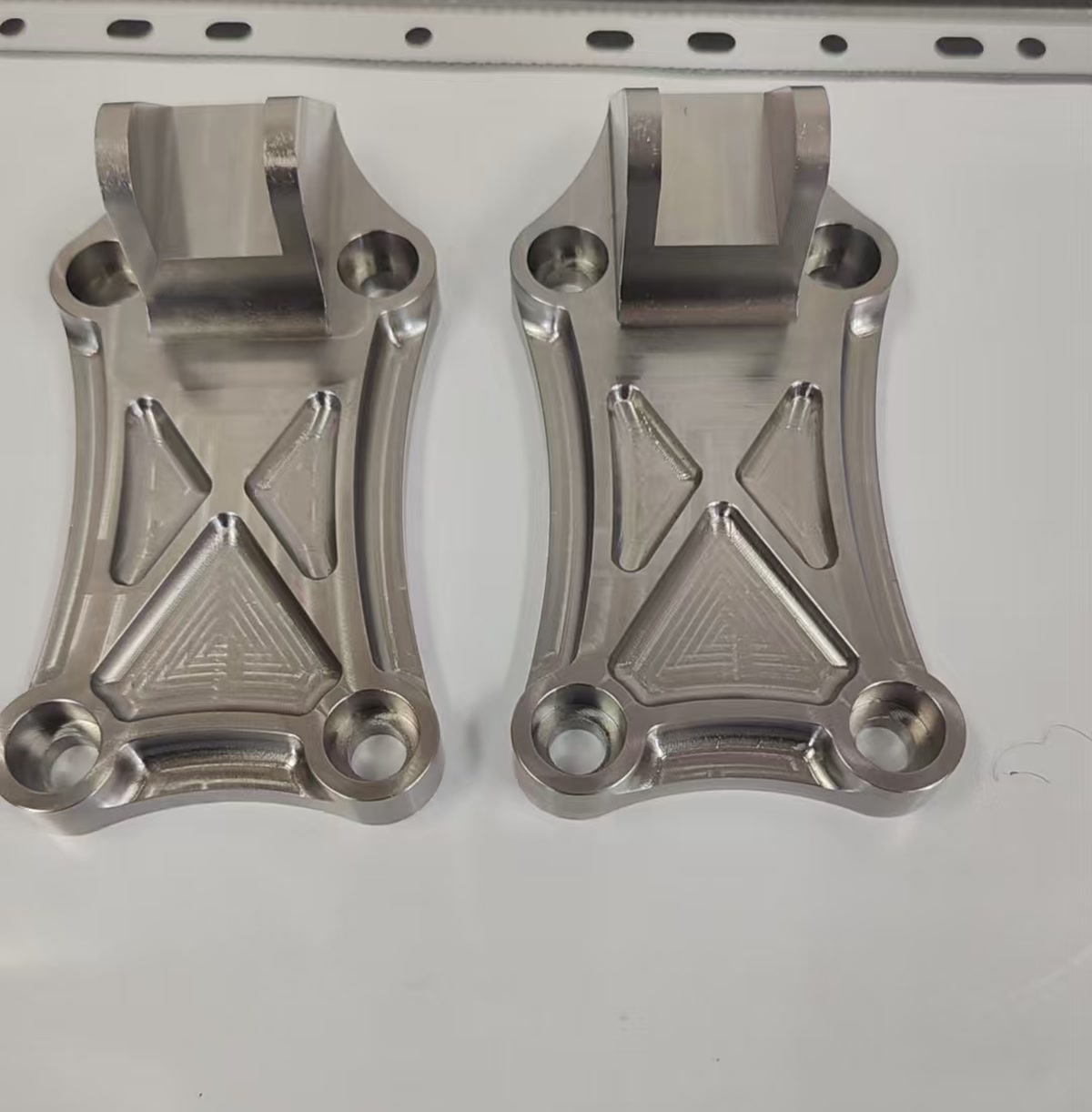 Machined pockets and holes on two anonymized titanium components