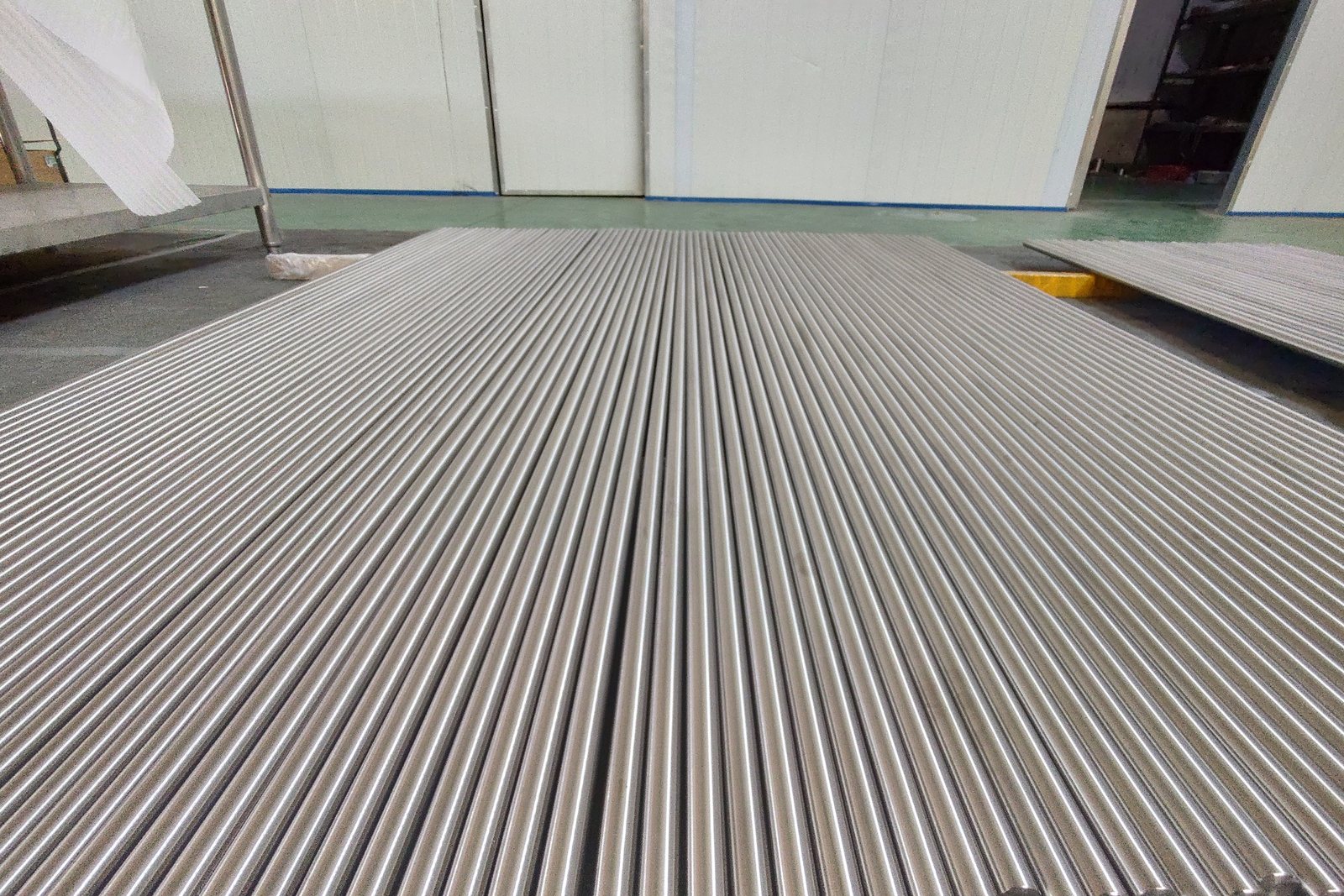Polished titanium round bar laid out on the finishing floor