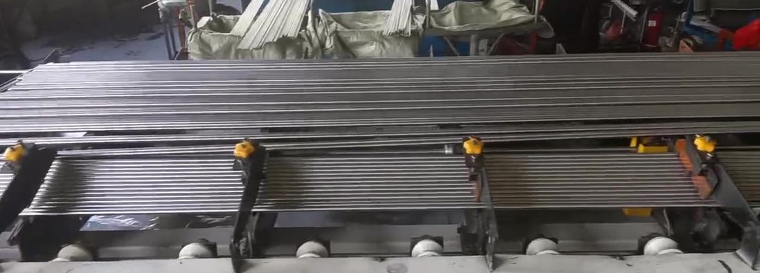 Titanium bar passing through eddy current inspection heads on the finishing line