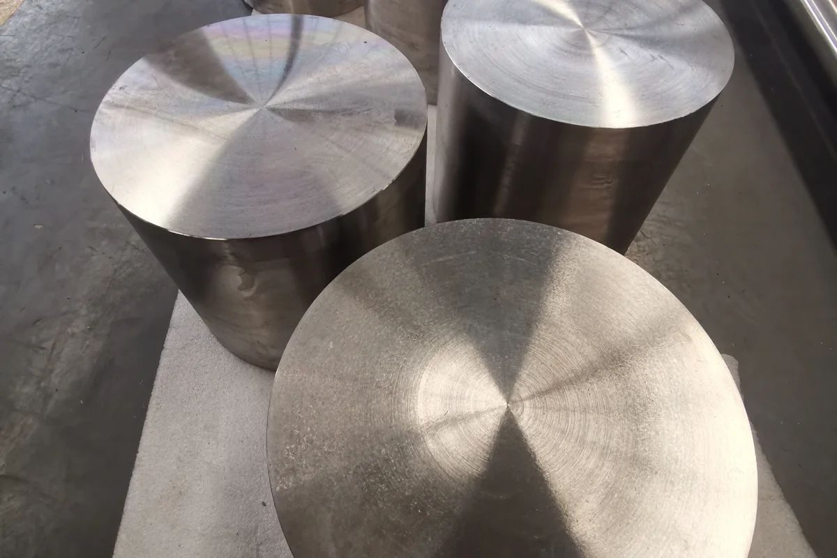 Titanium forged disc alongside round bar stock, showing shape families ordered from the same grade