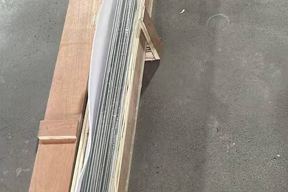 Titanium round bar in straight cut lengths, film wrapped and packed in a long timber crate for export