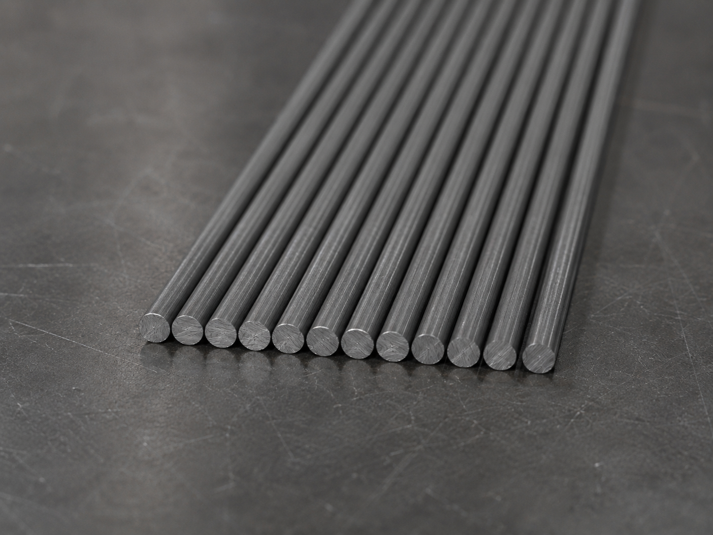 Twelve thin tungsten rods laid parallel with their cut ends toward the camera